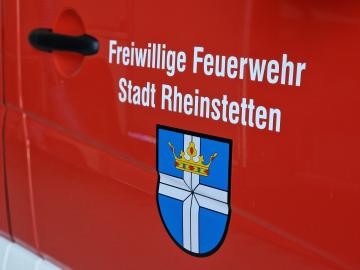 Autotür eines Feuerwehrfahrzeuges mit dem Schriftzug "Freiwillige Feuerwehr Rheinstetten" und dem Wappen Rheinstettens.