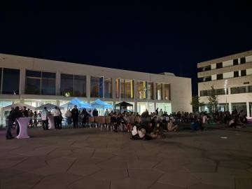 Marktplatz bei Dunkelheit mit vielen Leuten beim Kino-Event