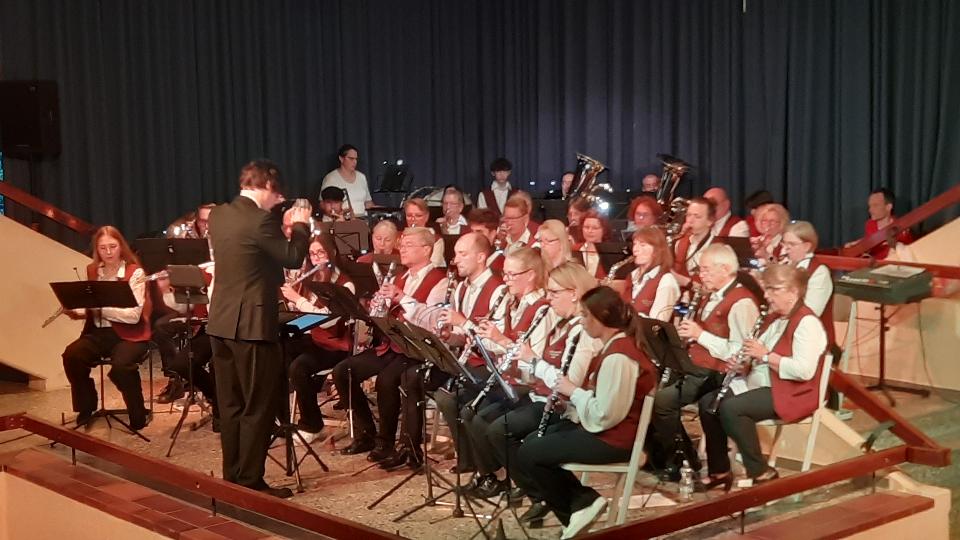 Aktive Musikerinnen und Musiker des Musikvereins Harmonie mit Dirigent auf der Bühne